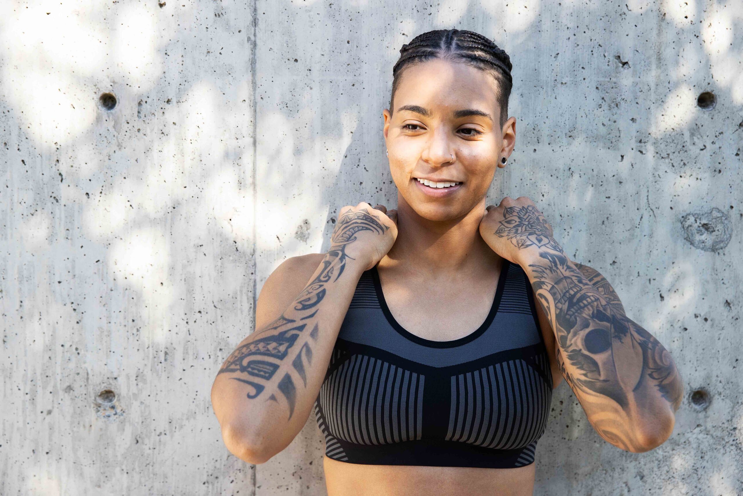 Strong, athletic African American woman with tattoos wearing ath