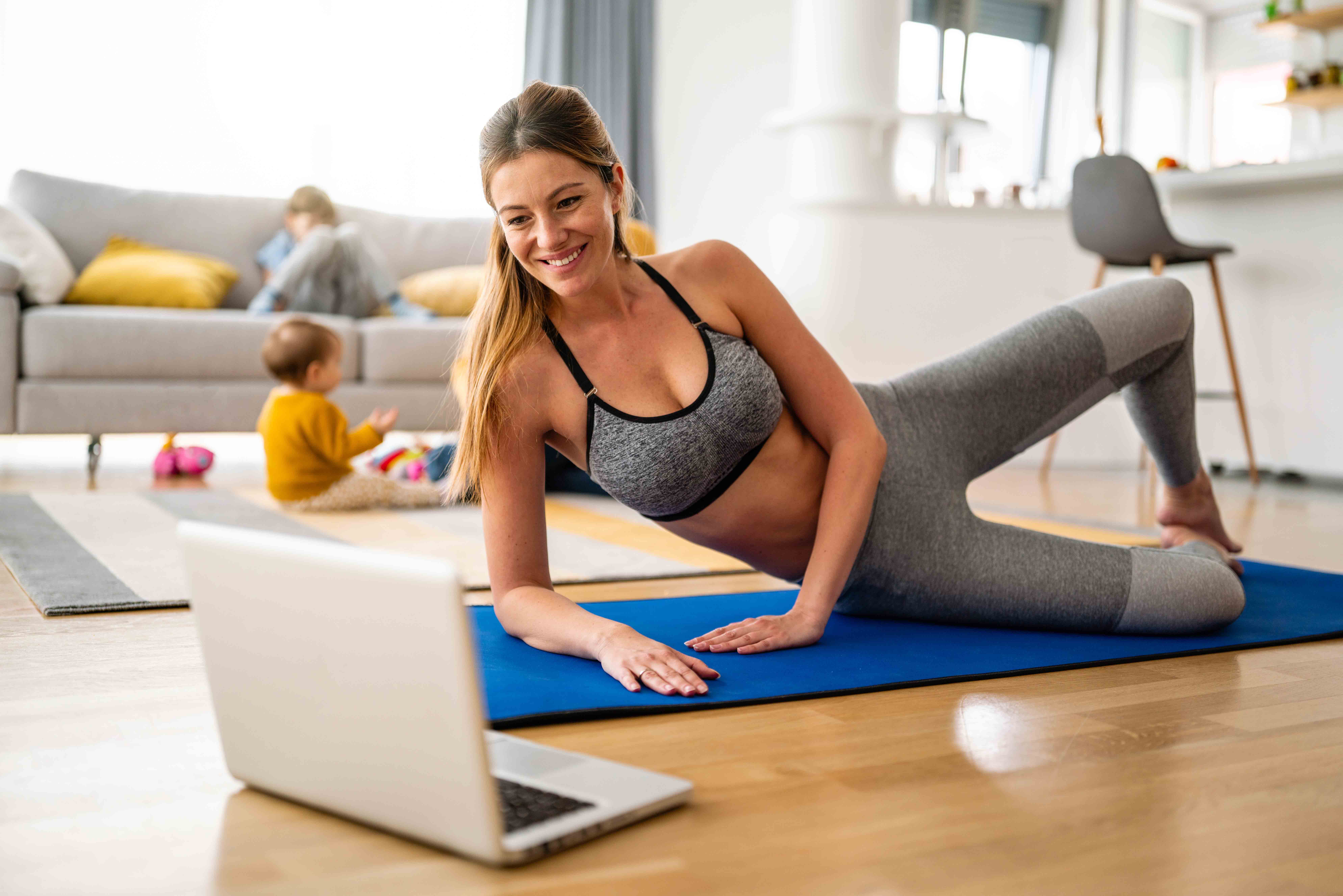 Young woman, mother is exercising at home. Fitness, workout, healthy living and diet concept.